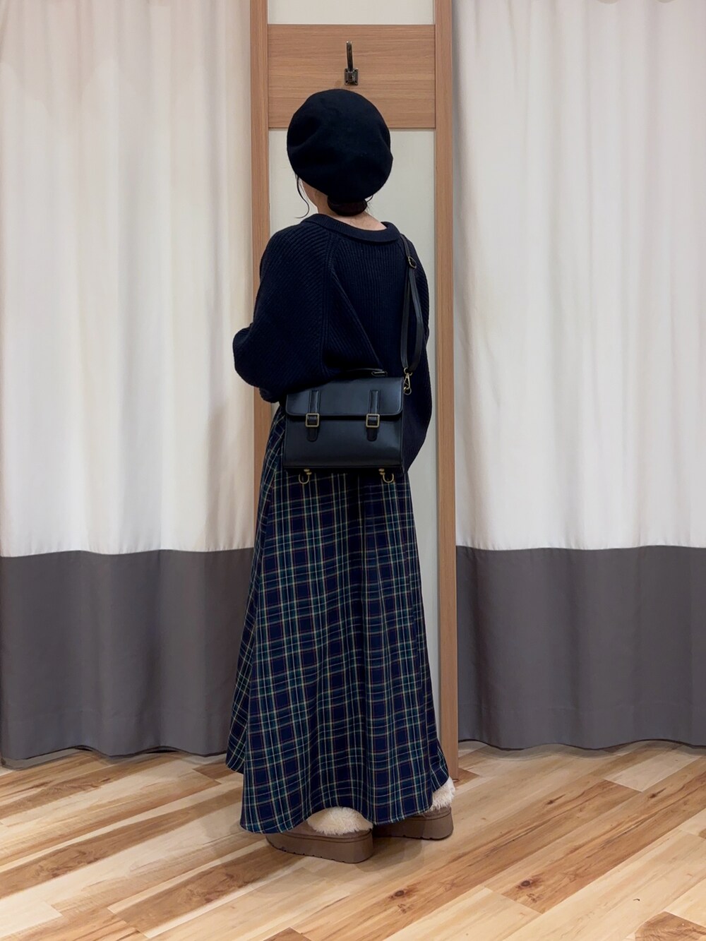 ブルー系のニット/セーター、ブラック系のハンドバッグ、ブルー系のスカートを着用したレディースの冬コーディネートの2枚目の写真