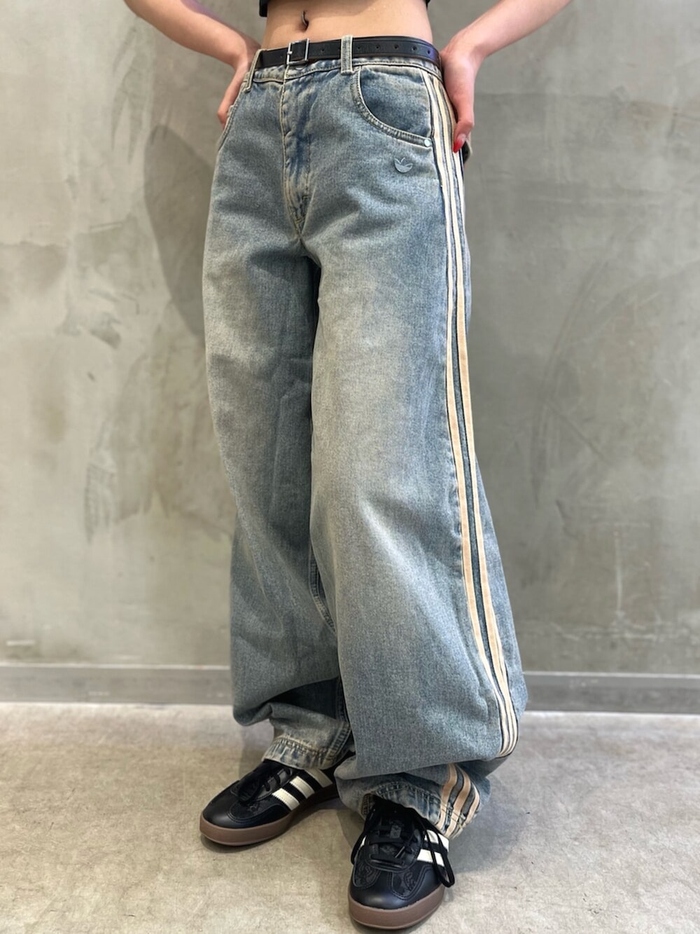 ブラック系のTシャツ/カットソー、ベージュ系のショルダーバッグ、ブルー系のデニムパンツを着用したレディースの秋コーディネートの4枚目の写真