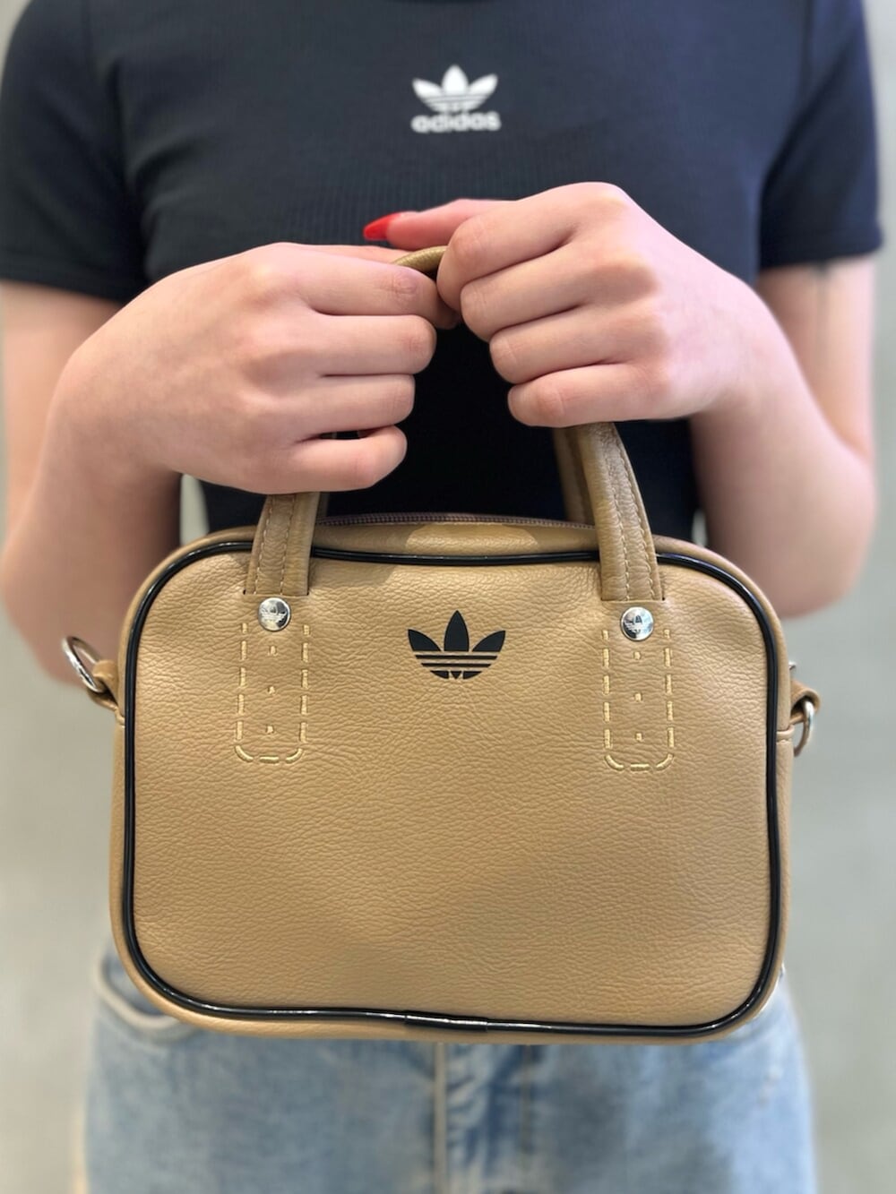 ブラック系のTシャツ/カットソー、ベージュ系のショルダーバッグ、ブルー系のデニムパンツを着用したレディースの秋コーディネートの5枚目の写真