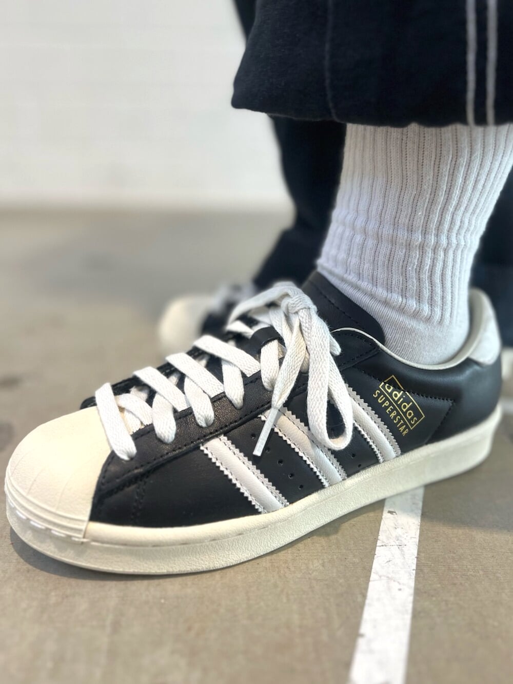 ブラック系のエコバッグ/サブバッグ、ブラック系のデニムパンツ、ブラック系のシューズを着用したレディースの冬コーディネートの6枚目の写真