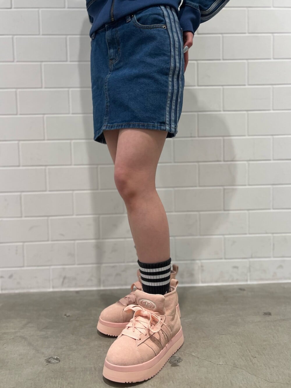 ブラック系のショルダーバッグ、ピンク系のシューズ、ブルー系のジャージを着用したレディースの冬コーディネートの5枚目の写真