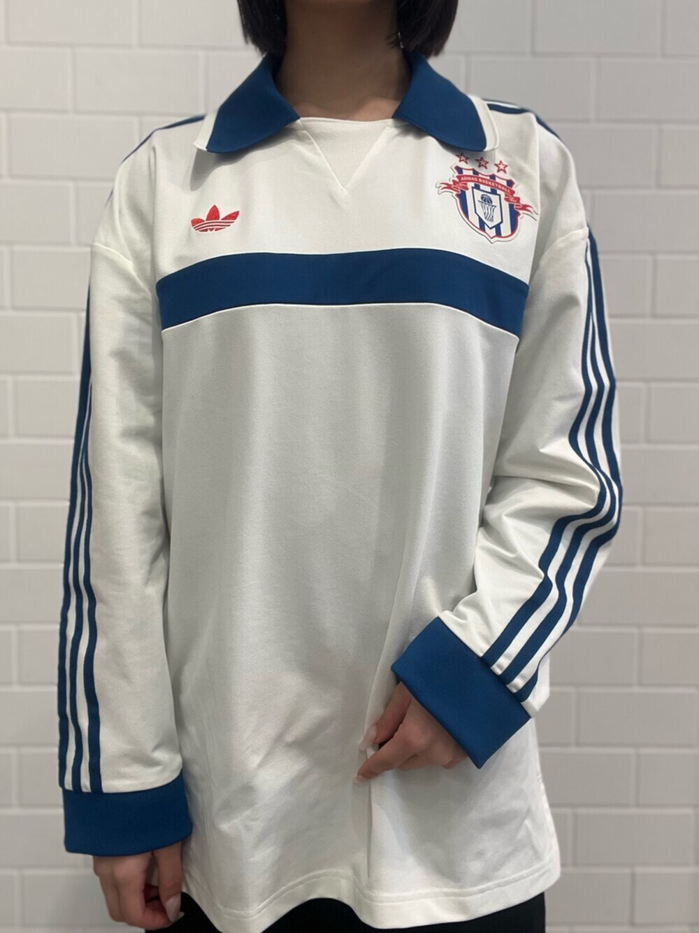 レッド系のスニーカー、ブラック系のショルダーバッグ、ホワイト系のポロシャツを着用したレディースの春コーディネートの4枚目の写真