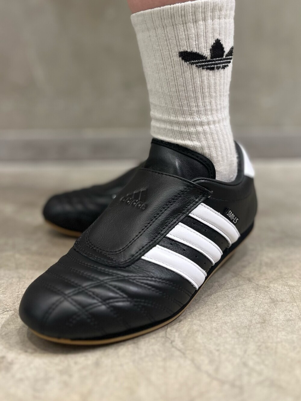 ブラック系のシューズ、ブラック系のデニムパンツ、グレー系のトップスを着用したレディースの春コーディネートの6枚目の写真