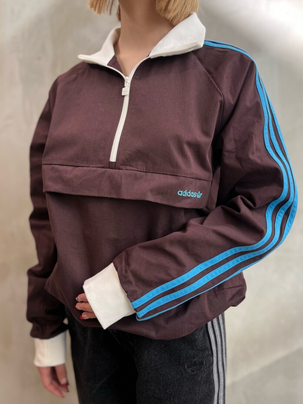 ブラック系のデニムパンツ、ブラウン系のスニーカー、ブラウン系のトップスを着用したレディースの冬コーディネートの4枚目の写真