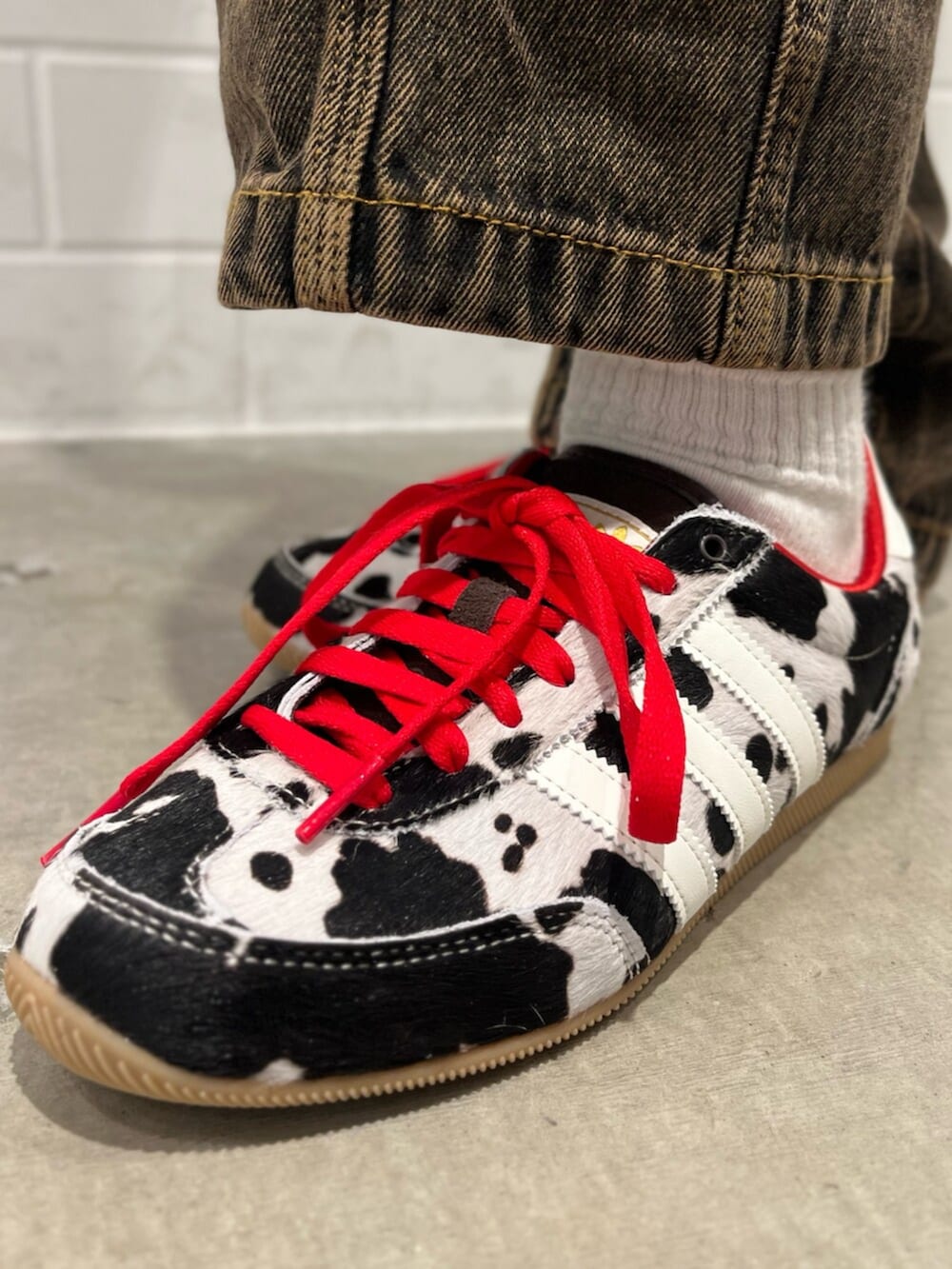 ブラック系のショルダーバッグ、ホワイト系のジャージ、ブラウン系のパンツを着用したレディースの冬コーディネートの6枚目の写真