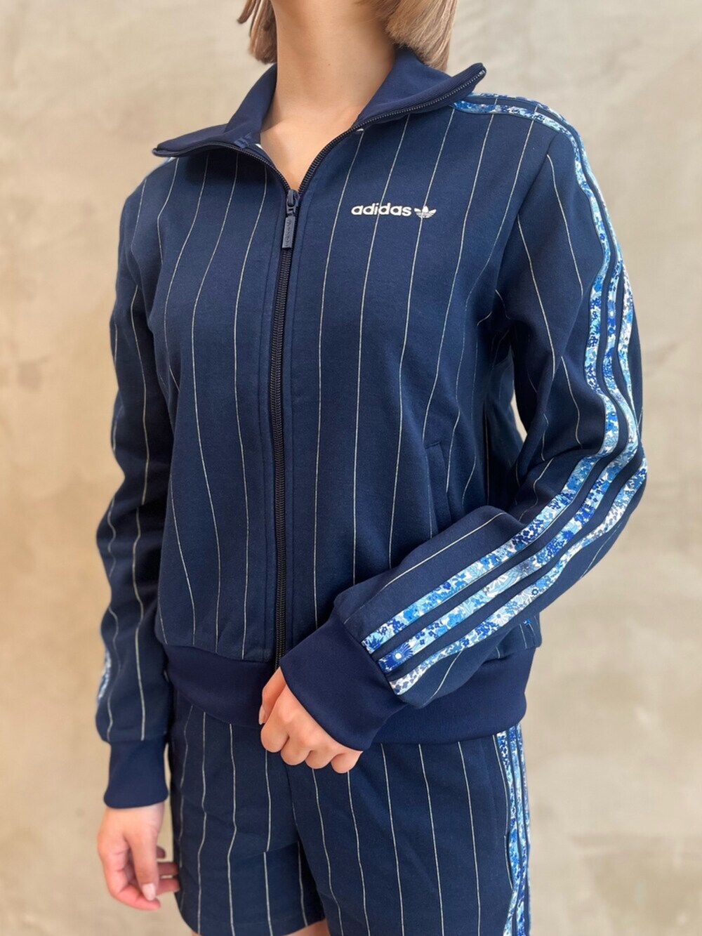 ブラック系のショルダーバッグ、ブラック系のスニーカー、ブルー系のトップスを着用したレディースの春コーディネートの3枚目の写真