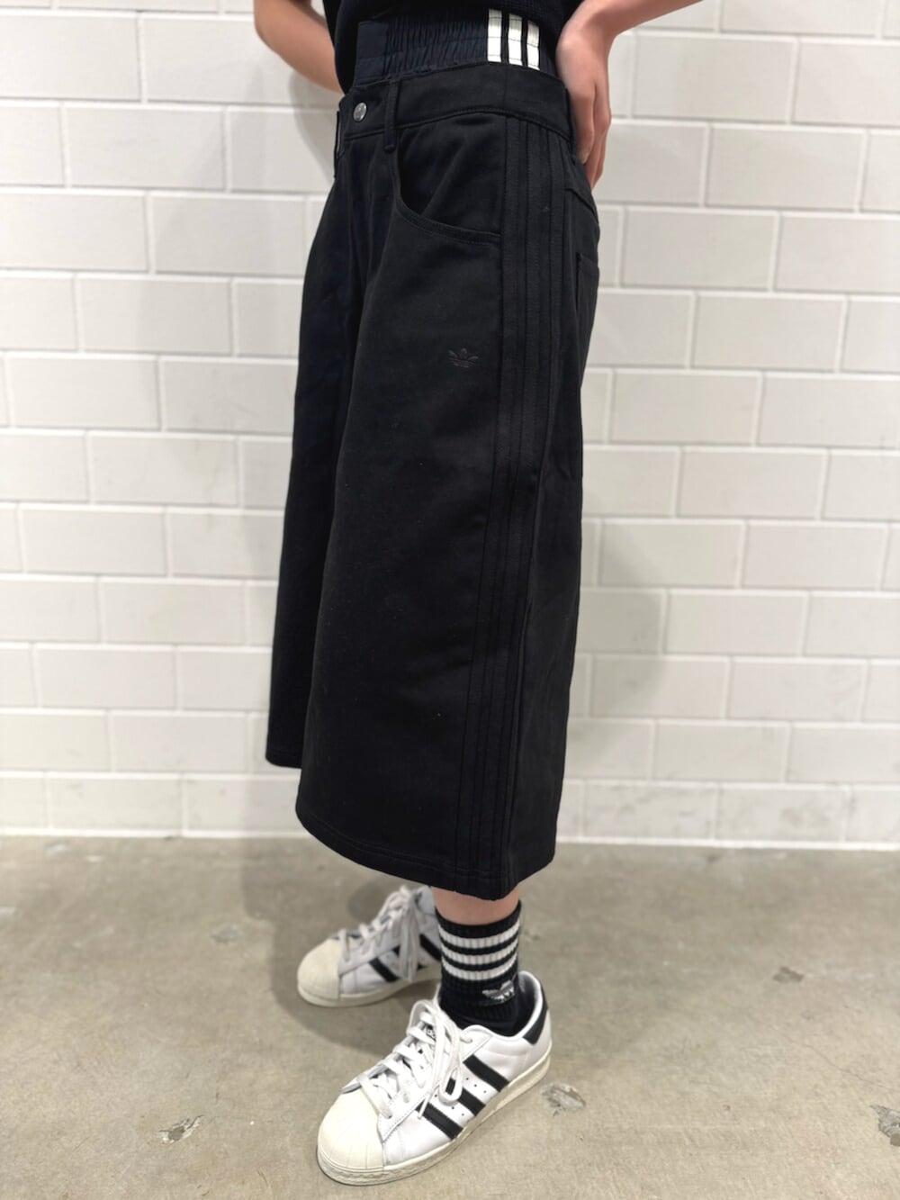 ブラック系のその他パンツ、ホワイト系のシューズ、ブラック系のポロシャツを着用したレディースの秋コーディネートの5枚目の写真