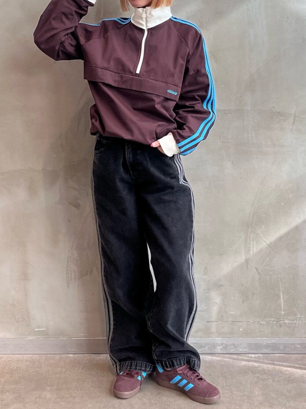 ブラック系のデニムパンツ、ブラウン系のスニーカー、ブラウン系のトップスを着用したレディースの冬コーディネートの2枚目の写真