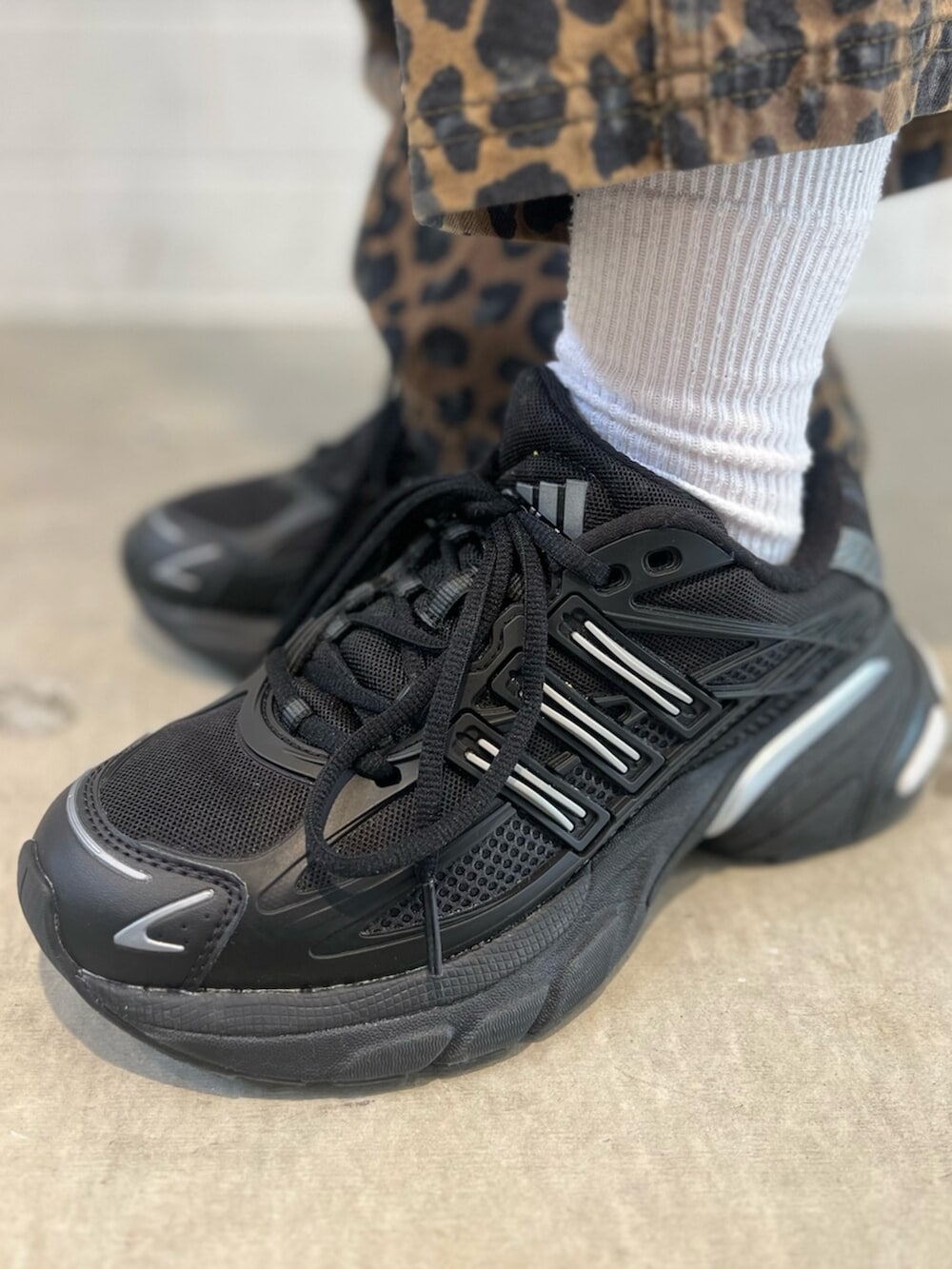 ブラック系のショルダーバッグ、ブラック系のスニーカー、ホワイト系のトップスを着用したレディースの冬コーディネートの8枚目の写真