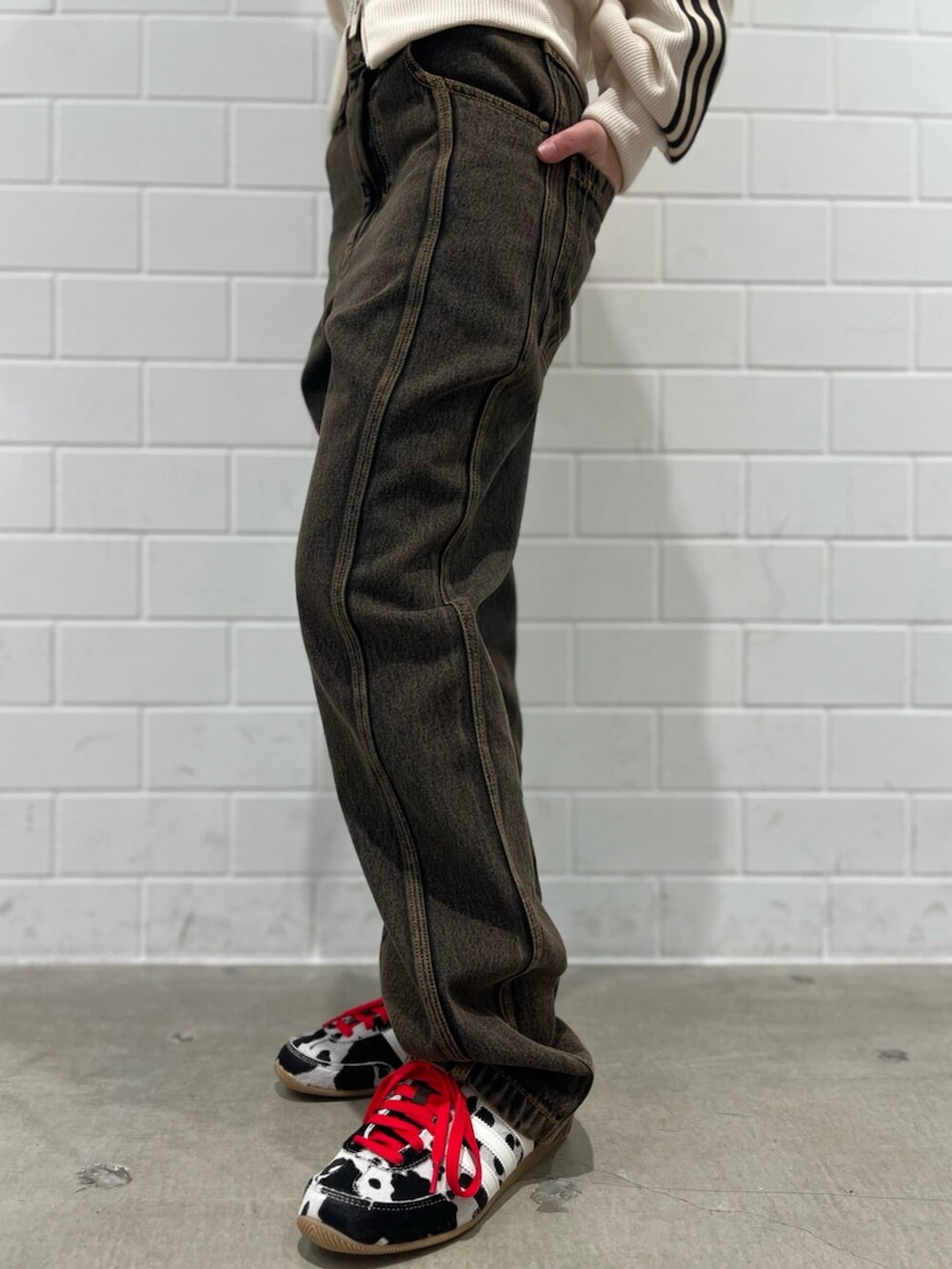 ブラック系のショルダーバッグ、ホワイト系のジャージ、ブラウン系のパンツを着用したレディースの冬コーディネートの5枚目の写真