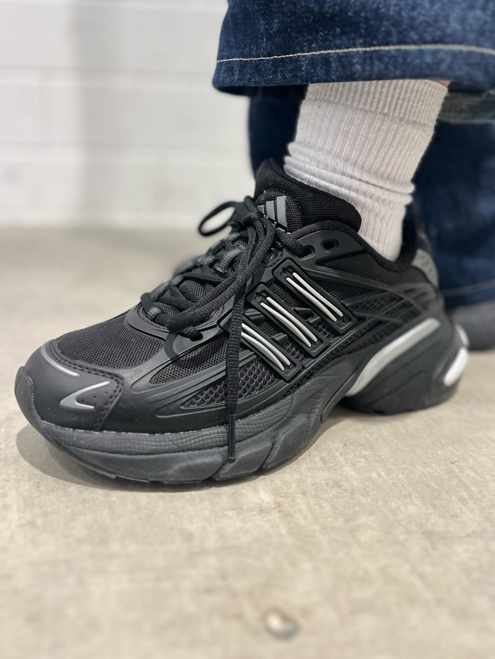 ブラック系のスニーカー、ブルー系のTシャツ/カットソー、ブラック系のトートバッグを着用したレディースの冬コーディネートの6枚目の写真