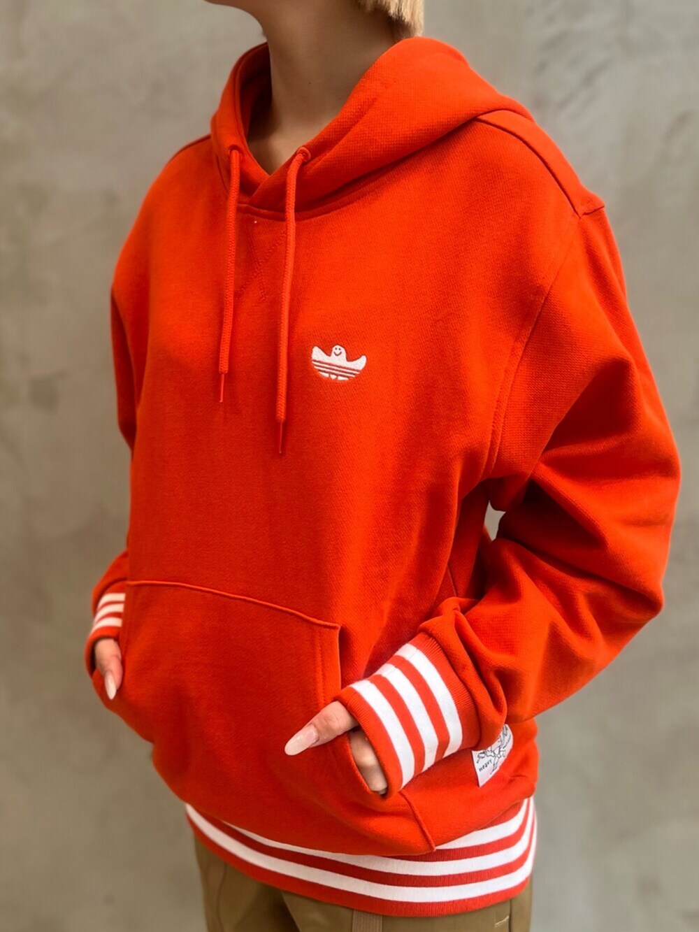 ブラウン系のカーゴパンツ、ホワイト系のシューズ、オレンジ系のパーカーを着用したレディースの冬コーディネートの5枚目の写真