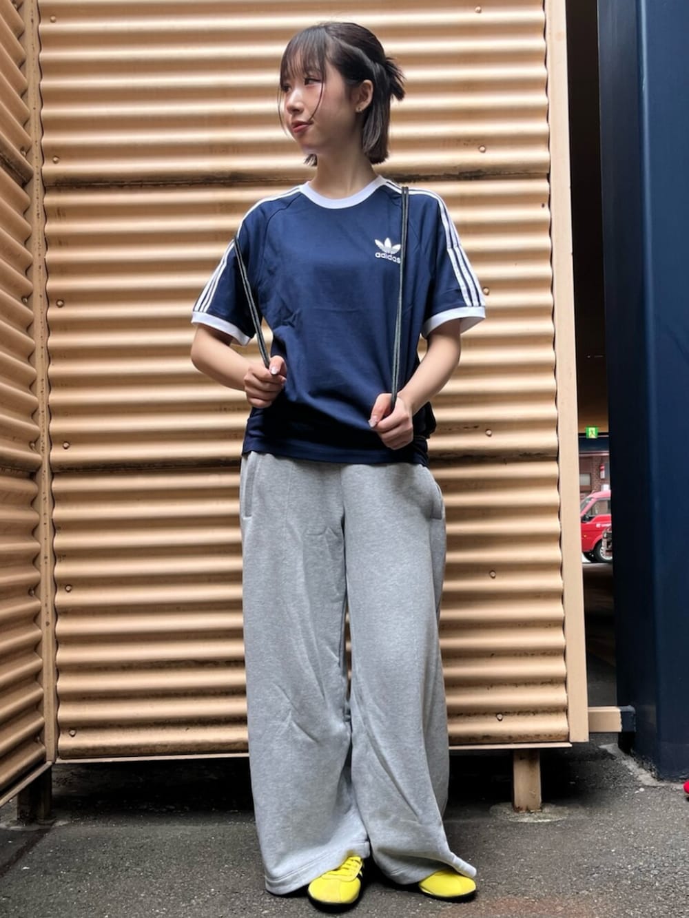 ブラック系のエコバッグ/サブバッグ、ブルー系のTシャツ/カットソー、イエロー系のスニーカーを着用したレディースの夏コーディネートの3枚目の写真