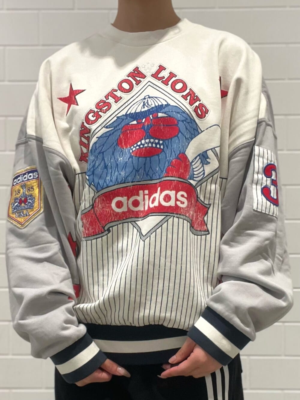 ブラック系のショルダーバッグ、レッド系のスニーカー、ブラック系のデニムパンツを着用したレディースの秋コーディネートの4枚目の写真