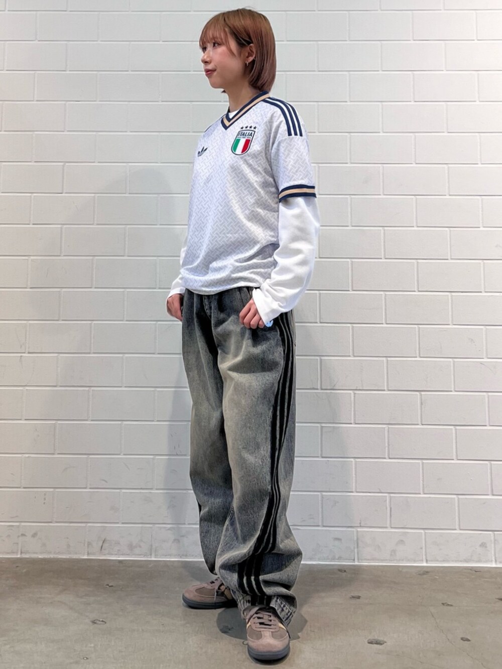 ブラウン系のスニーカー、ブルー系のTシャツ/カットソー、ブラウン系のデニムパンツを着用したレディースの春コーディネートの3枚目の写真