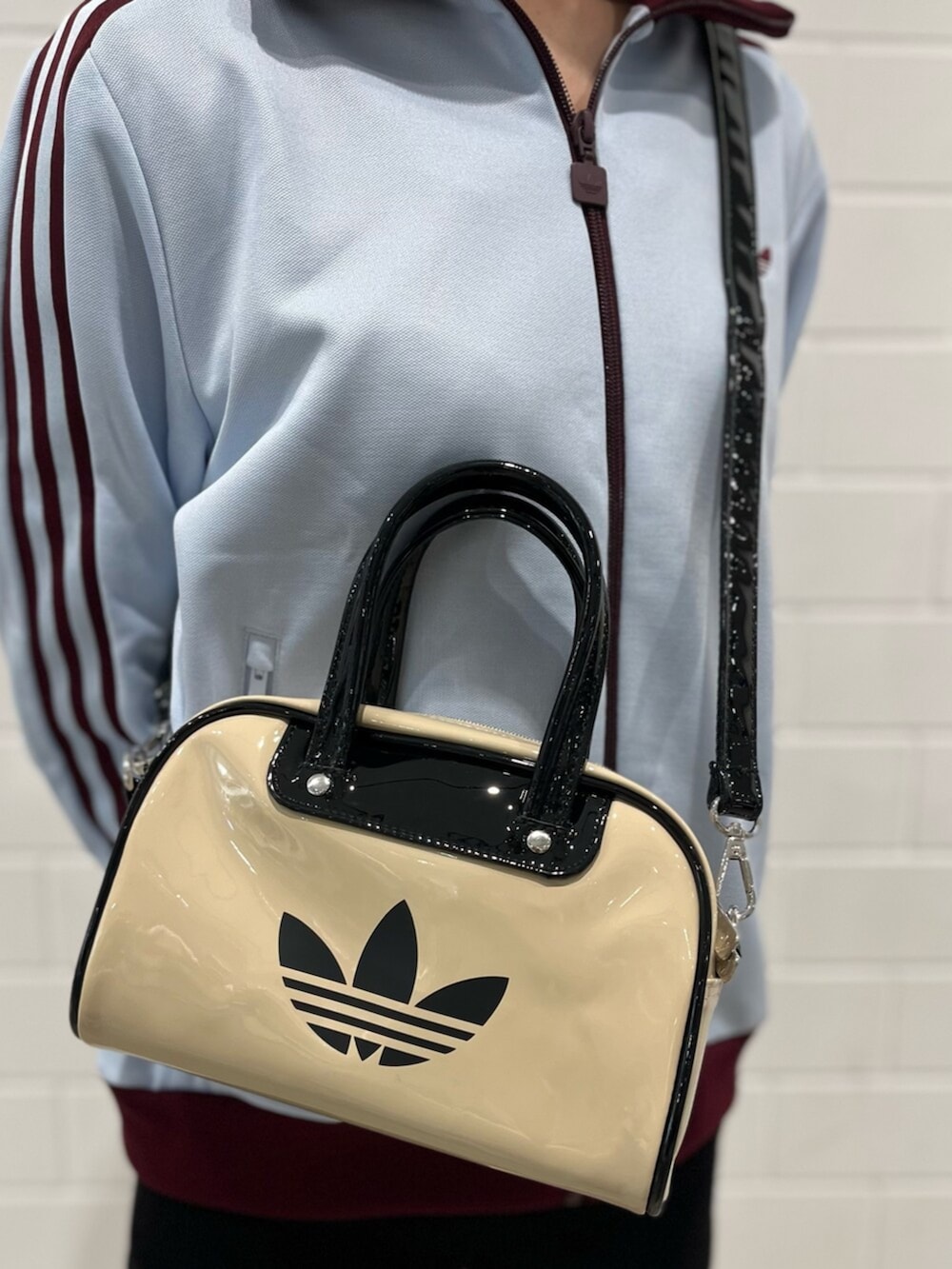 ベージュ系のショルダーバッグ、グリーン系のスニーカー、ブルー系のジャージを着用したレディースの春コーディネートの5枚目の写真