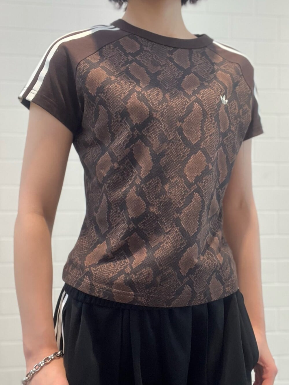 ブラック系のスニーカー、ブラック系のエコバッグ/サブバッグ、ブラウン系のTシャツ/カットソーを着用したレディースの夏コーディネートの3枚目の写真