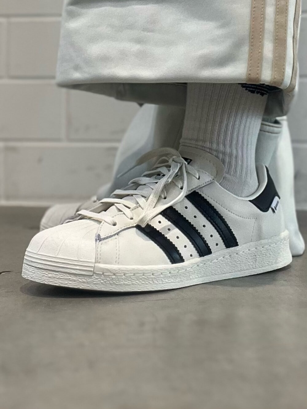 ブルー系のデニムパンツ、ホワイト系のシューズ、ブラック系のショルダーバッグを着用したレディースの春コーディネートの6枚目の写真