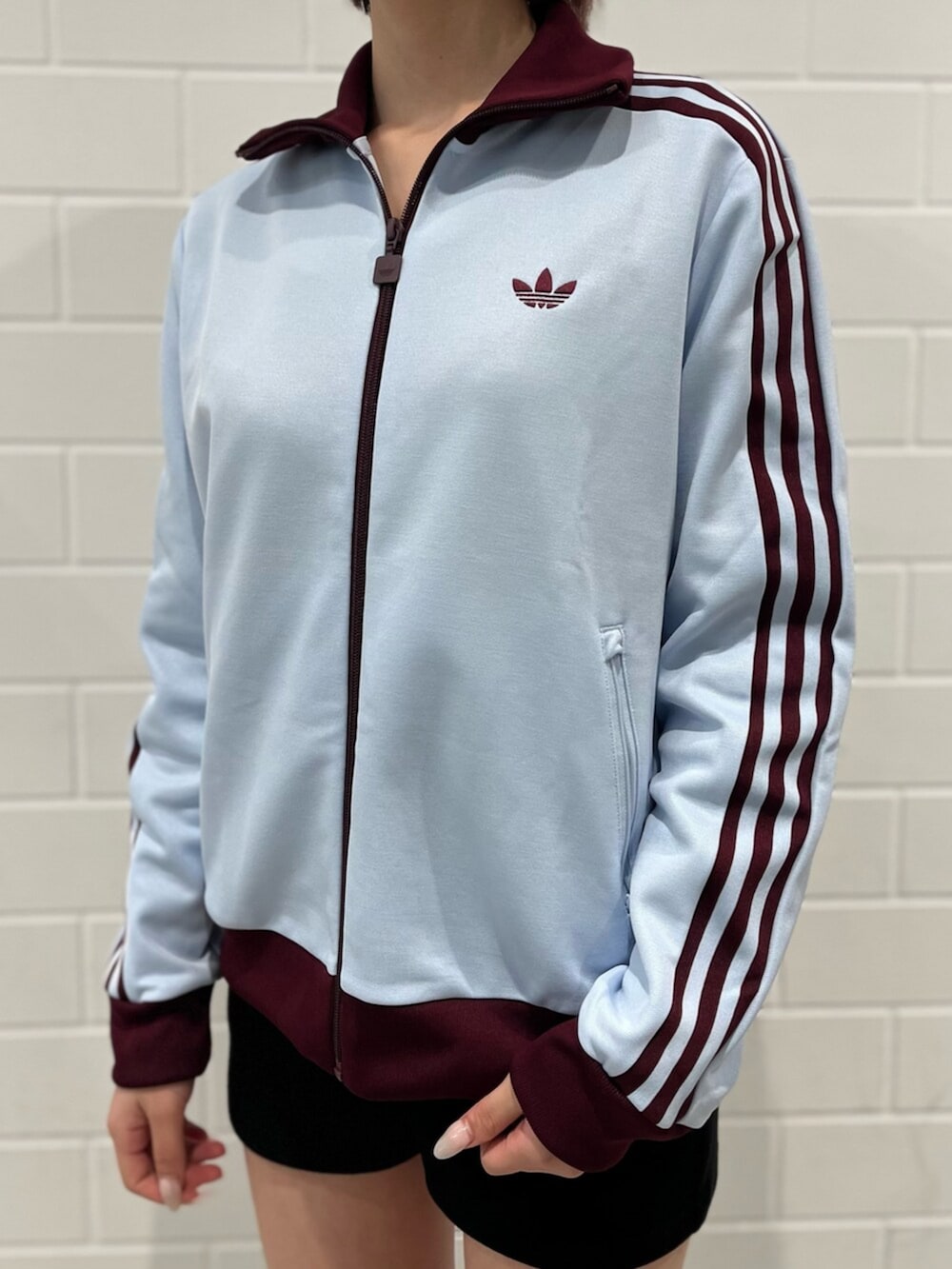 ベージュ系のショルダーバッグ、グリーン系のスニーカー、ブルー系のジャージを着用したレディースの春コーディネートの4枚目の写真