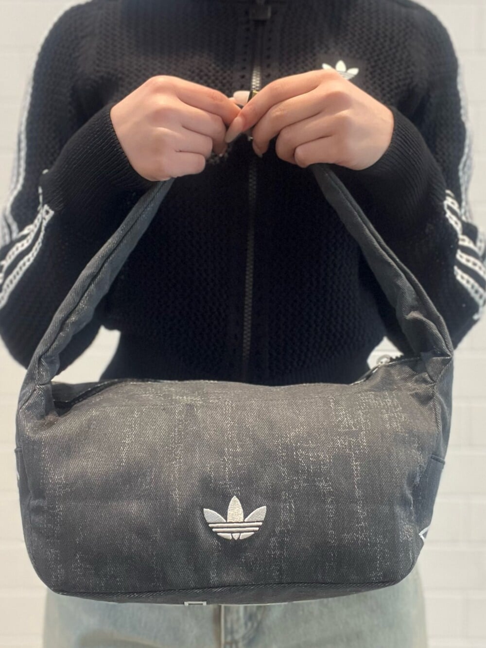 ブルー系のデニムパンツ、ホワイト系のシューズ、ブラック系のショルダーバッグを着用したレディースの春コーディネートの4枚目の写真