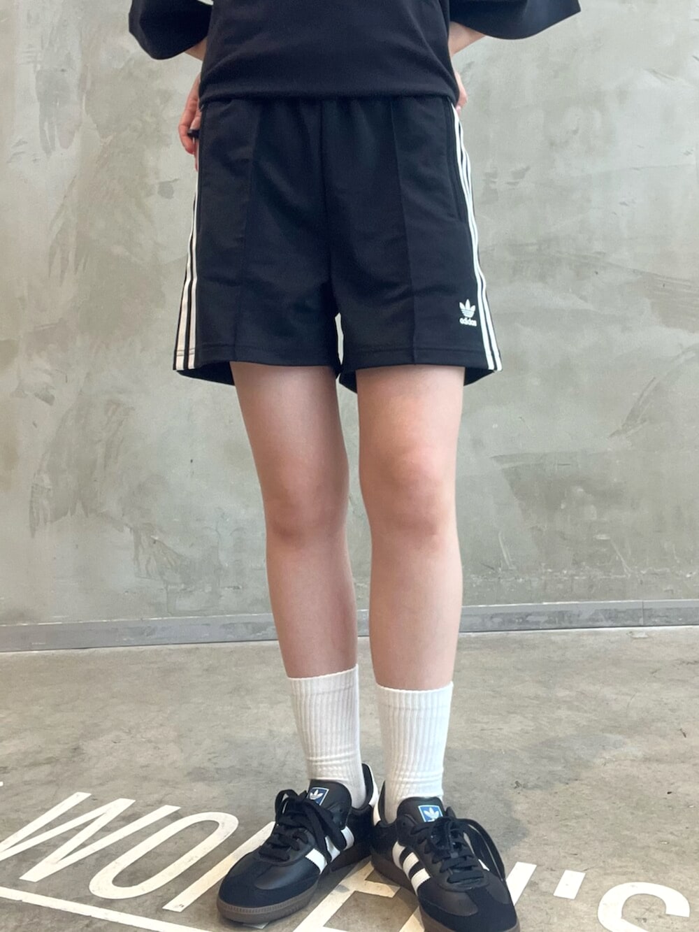 ブラウン系のショルダーバッグ、ブラック系のその他パンツ、ブラック系のポロシャツを着用したレディースの秋コーディネートの4枚目の写真