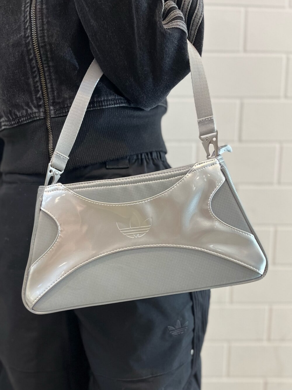 シルバー系のショルダーバッグ、ブラック系のデニムジャケット、ブラック系のその他パンツを着用したレディースの冬コーディネートの4枚目の写真