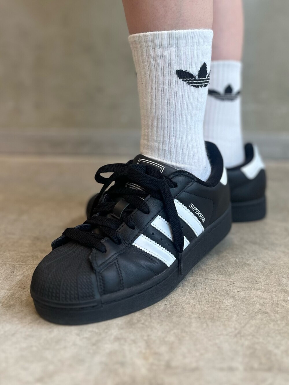 ブラック系のショルダーバッグ、ブラック系のスニーカー、ブルー系のトップスを着用したレディースの春コーディネートの6枚目の写真