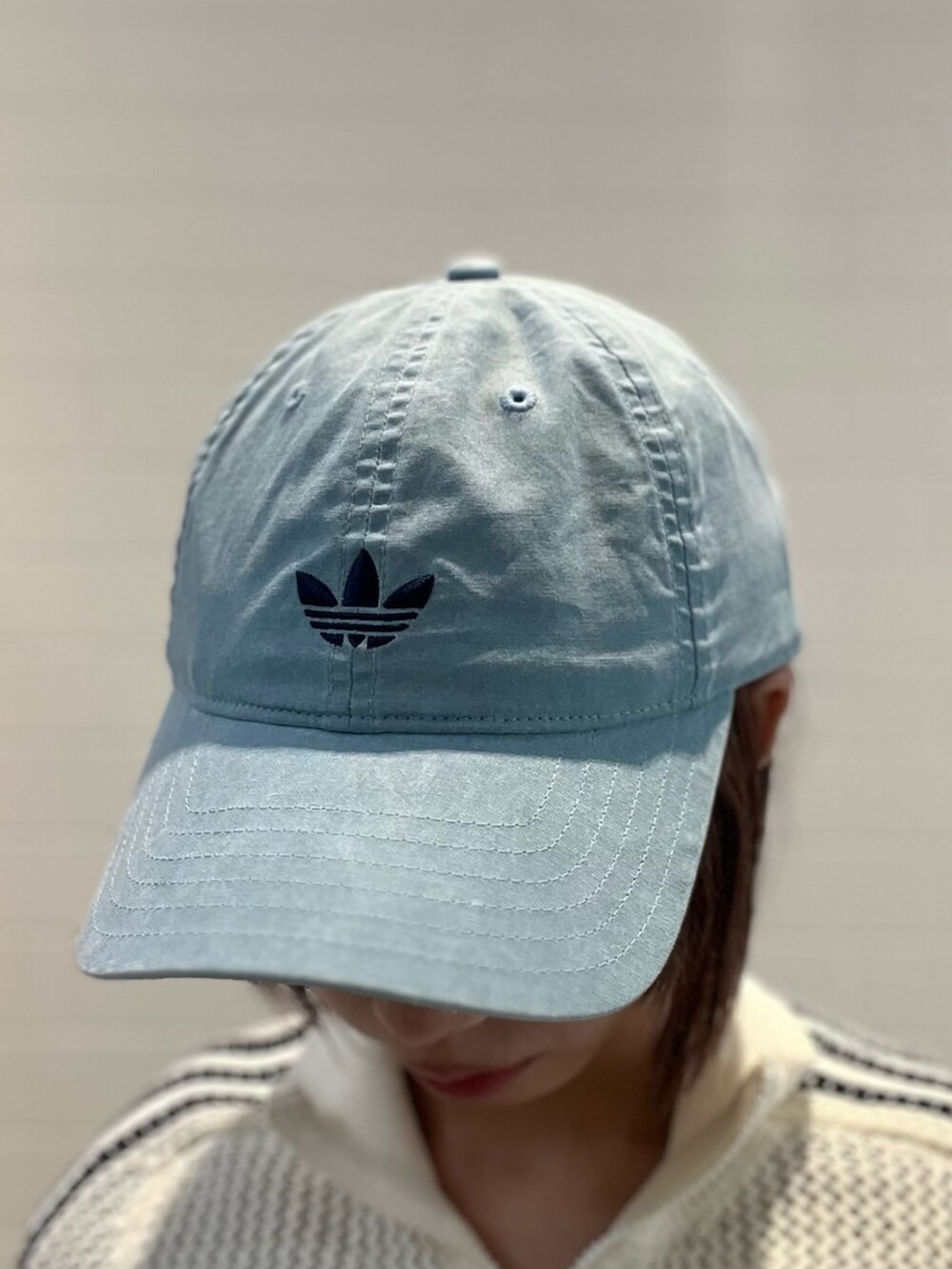 ブラック系のショルダーバッグ、ブラック系のスニーカー、ブルー系のデニムパンツを着用したレディースの春コーディネートの4枚目の写真