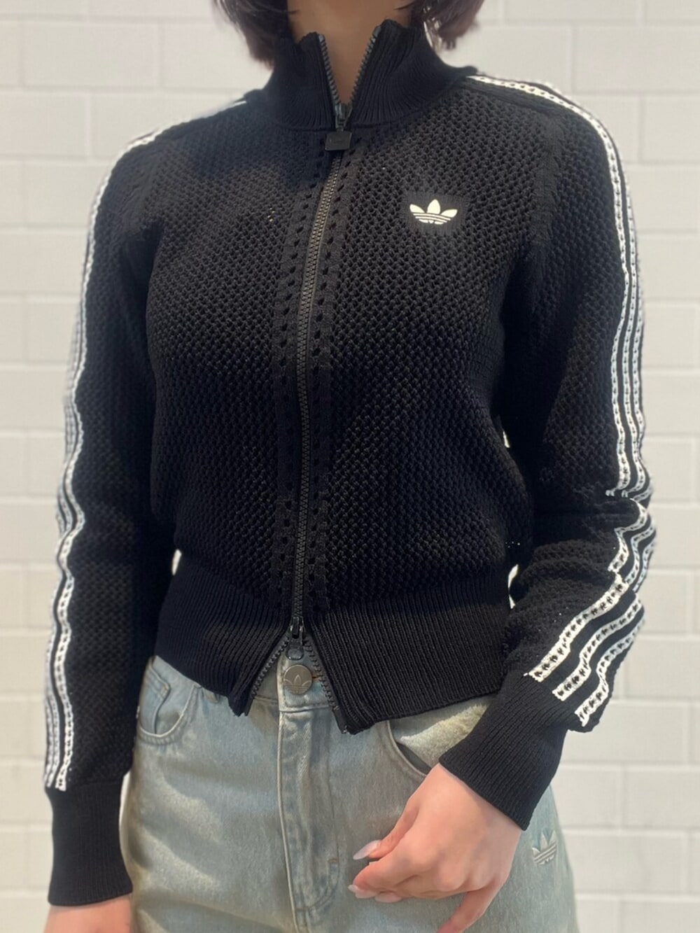 ブルー系のデニムパンツ、ホワイト系のシューズ、ブラック系のショルダーバッグを着用したレディースの春コーディネートの3枚目の写真