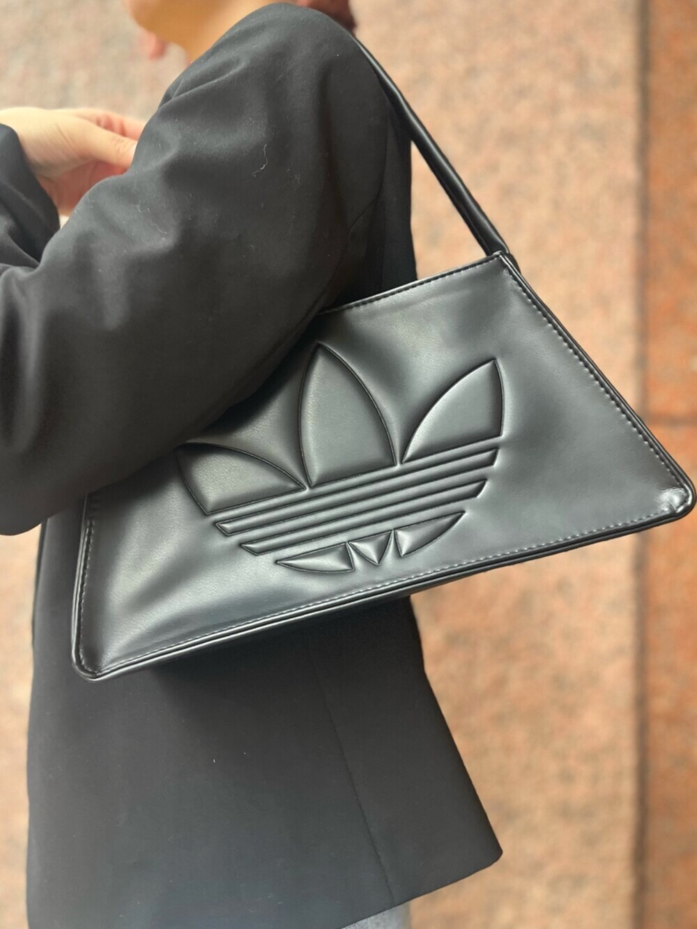 ブラック系のショルダーバッグ、ブラック系のシューズ、イエロー系のTシャツ/カットソーを着用したレディースの春コーディネートの5枚目の写真