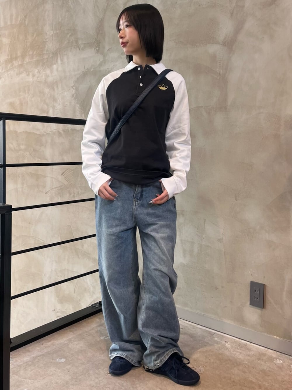 ブルー系のシューズ、ブルー系のショルダーバッグ、ブラック系のポロシャツを着用したレディースの冬コーディネートの3枚目の写真