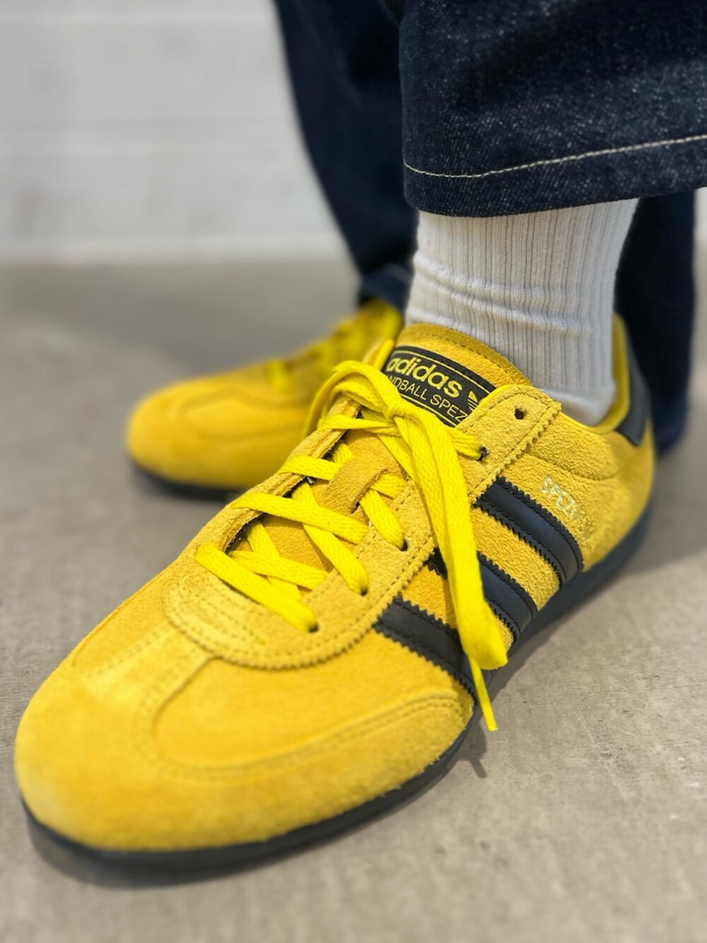 ブラック系のショルダーバッグ、イエロー系のスニーカー、グレー系のパーカーを着用したレディースの冬コーディネートの6枚目の写真