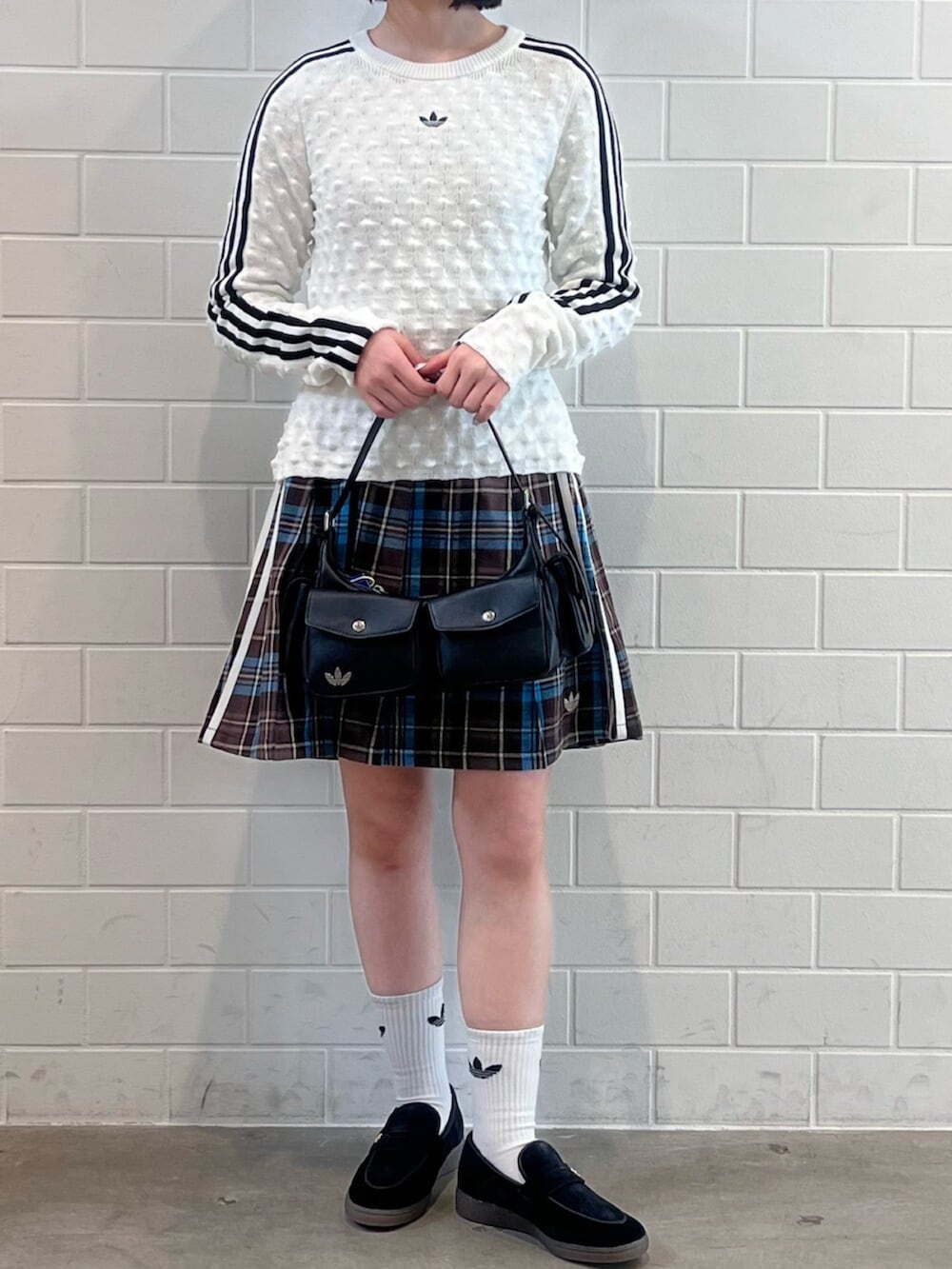 ホワイト系のスウェット、ブラック系のショルダーバッグ、ブラック系のスニーカーを着用したレディースの冬コーディネートの2枚目の写真