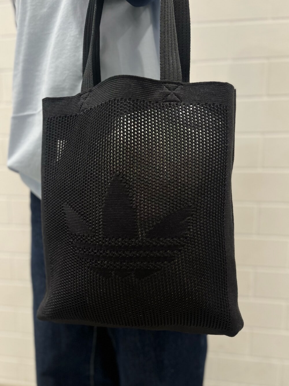 ブラック系のスニーカー、ブルー系のTシャツ/カットソー、ブラック系のトートバッグを着用したレディースの冬コーディネートの5枚目の写真