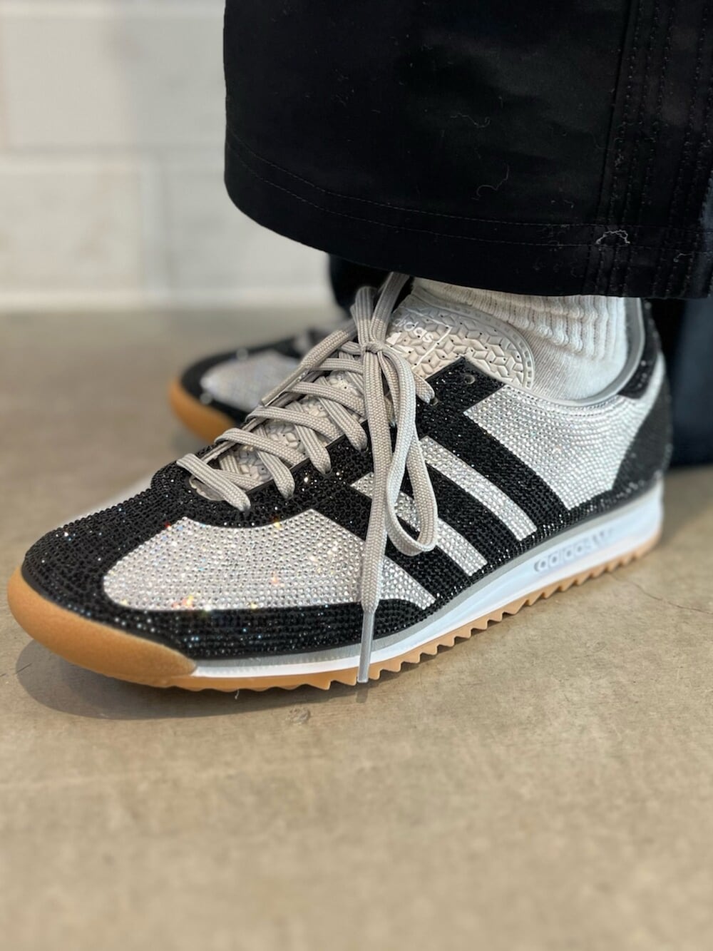 シルバー系のショルダーバッグ、ブラック系のデニムジャケット、ブラック系のその他パンツを着用したレディースの冬コーディネートの6枚目の写真