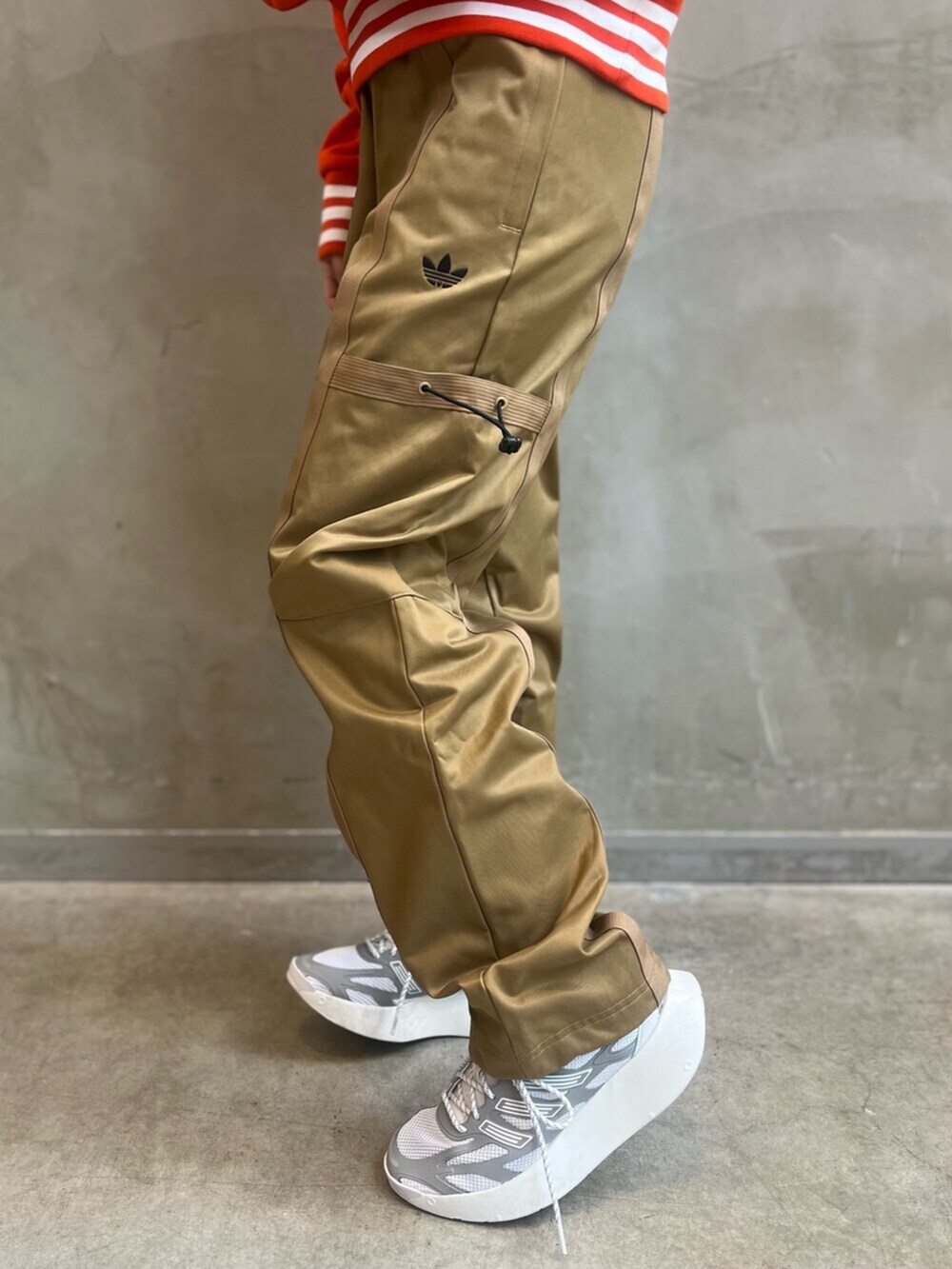 ブラウン系のカーゴパンツ、ホワイト系のシューズ、オレンジ系のパーカーを着用したレディースの冬コーディネートの6枚目の写真