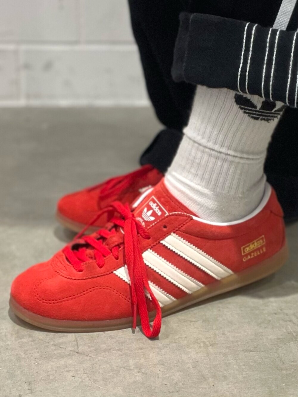 ブラック系のショルダーバッグ、レッド系のスニーカー、ブラック系のデニムパンツを着用したレディースの秋コーディネートの8枚目の写真