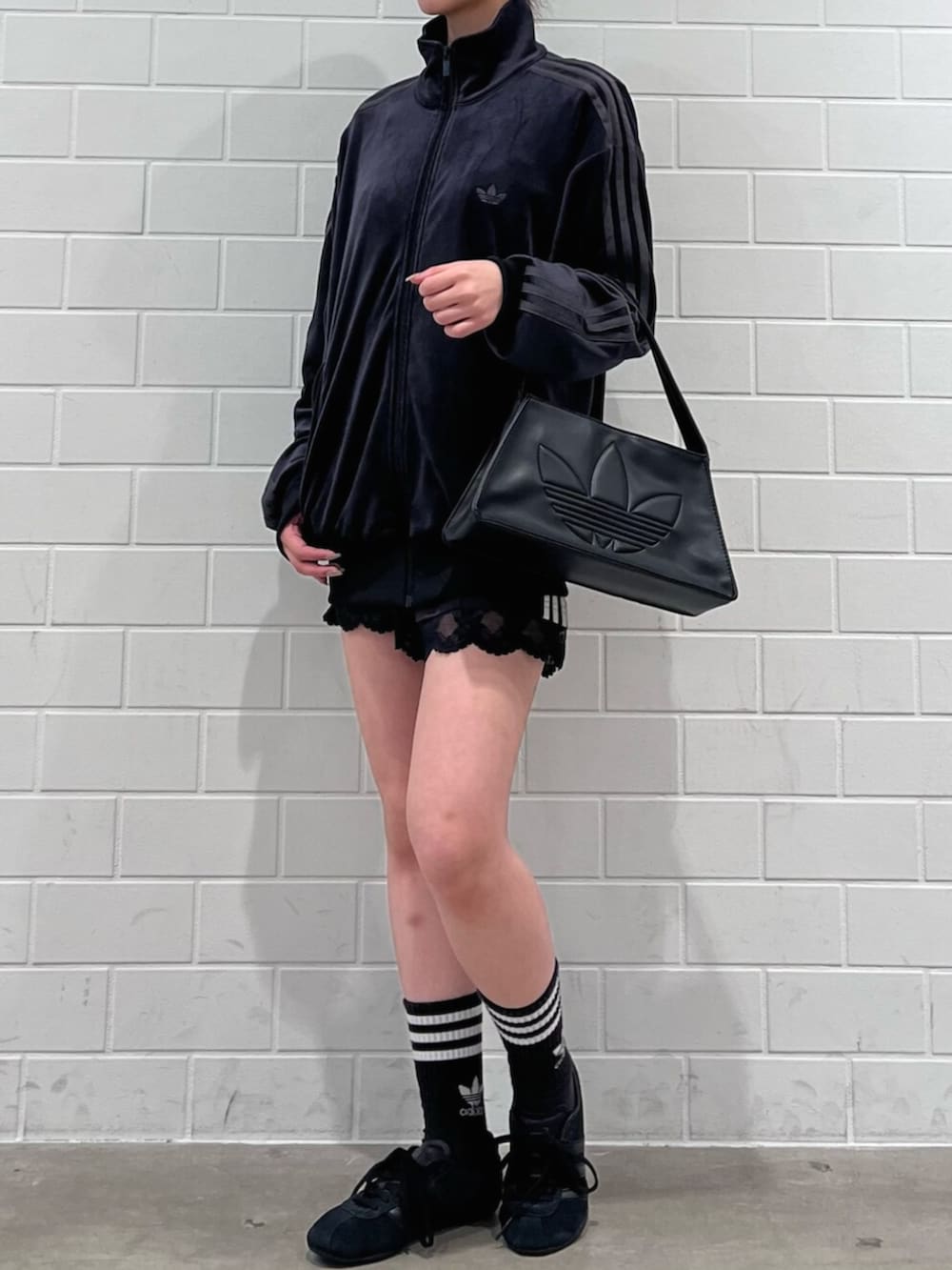 ブラック系のその他パンツ、ブラック系のショルダーバッグ、ブラック系のスニーカーを着用したレディースの冬コーディネートの2枚目の写真