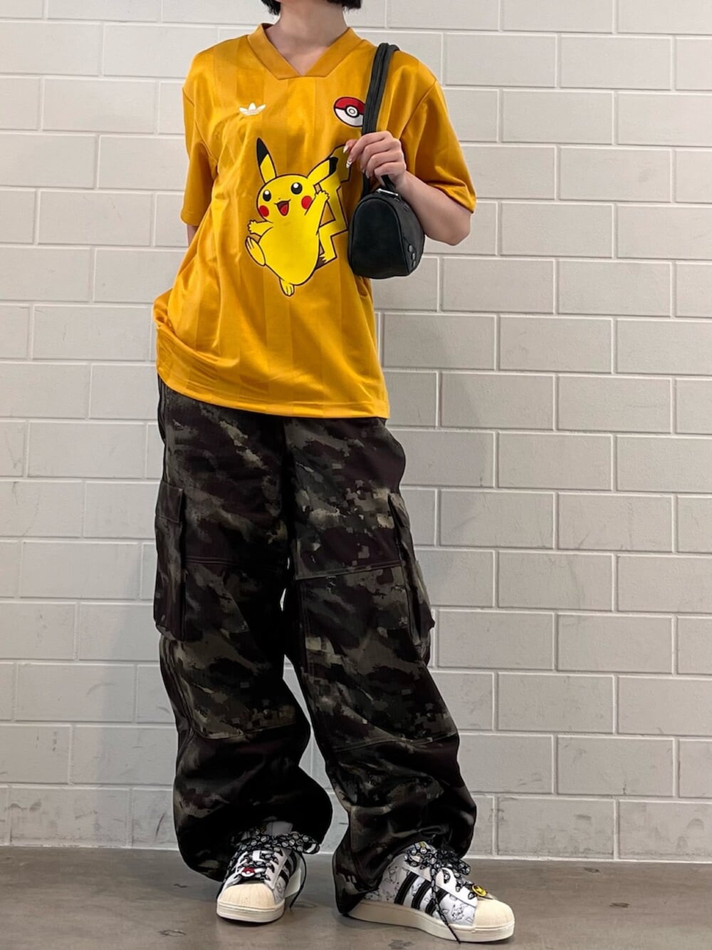 グリーン系のその他パンツ、イエロー系のTシャツ/カットソー、ホワイト系のスニーカーを着用したレディースの秋コーディネートの2枚目の写真