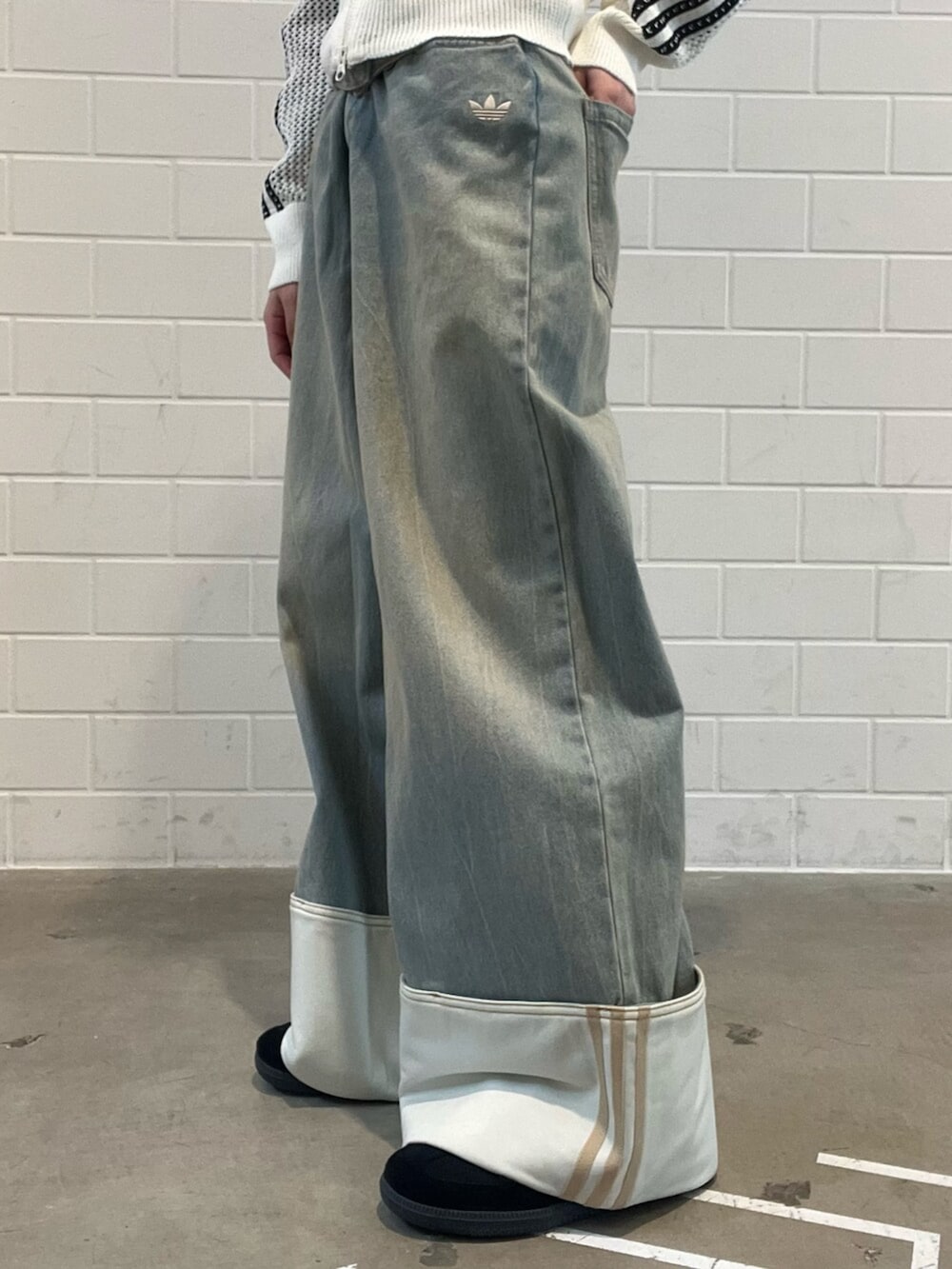 ブラック系のショルダーバッグ、ブラック系のスニーカー、ブルー系のデニムパンツを着用したレディースの春コーディネートの7枚目の写真