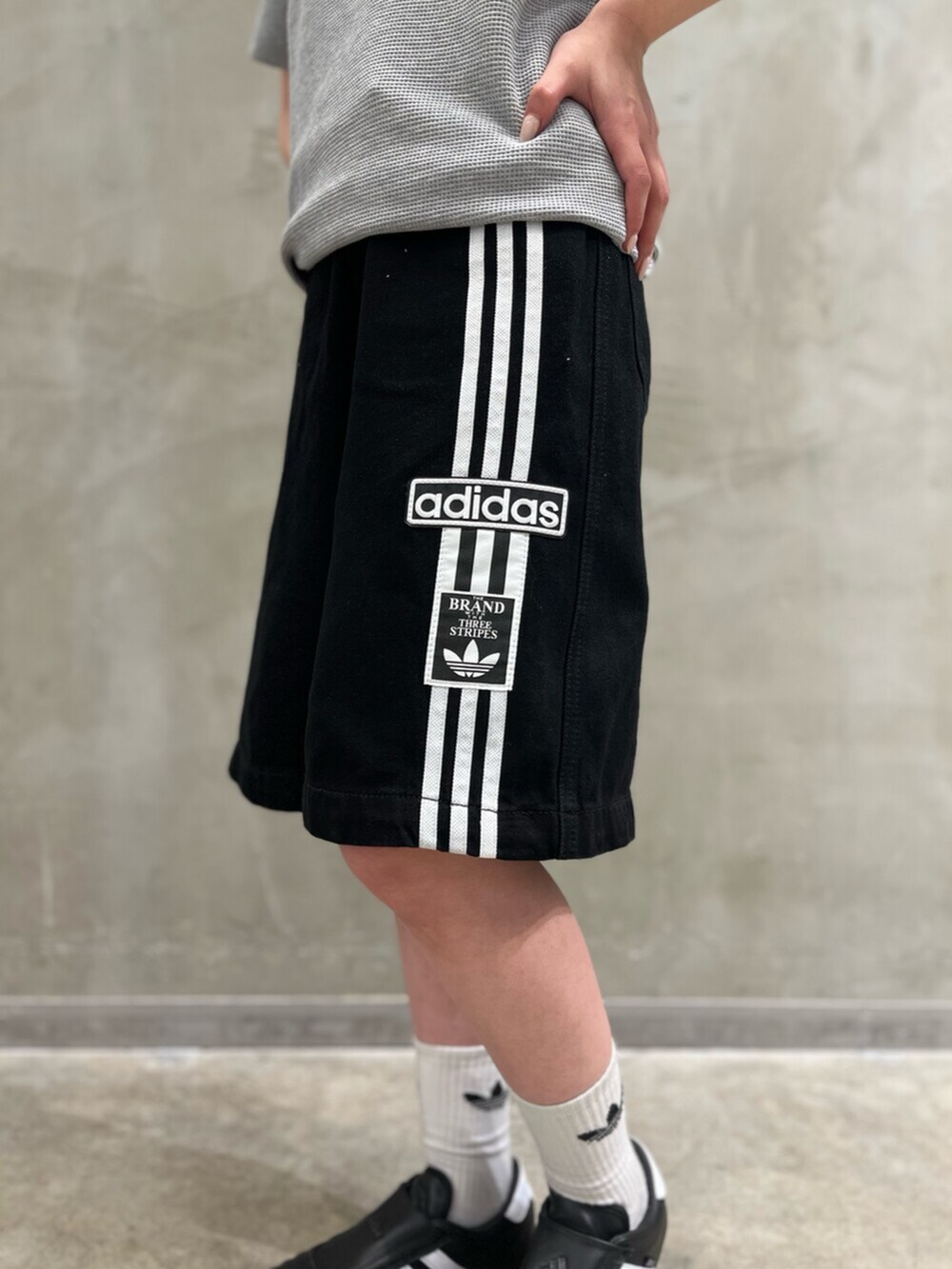 ブラック系のシューズ、ブラック系のデニムパンツ、グレー系のトップスを着用したレディースの春コーディネートの4枚目の写真