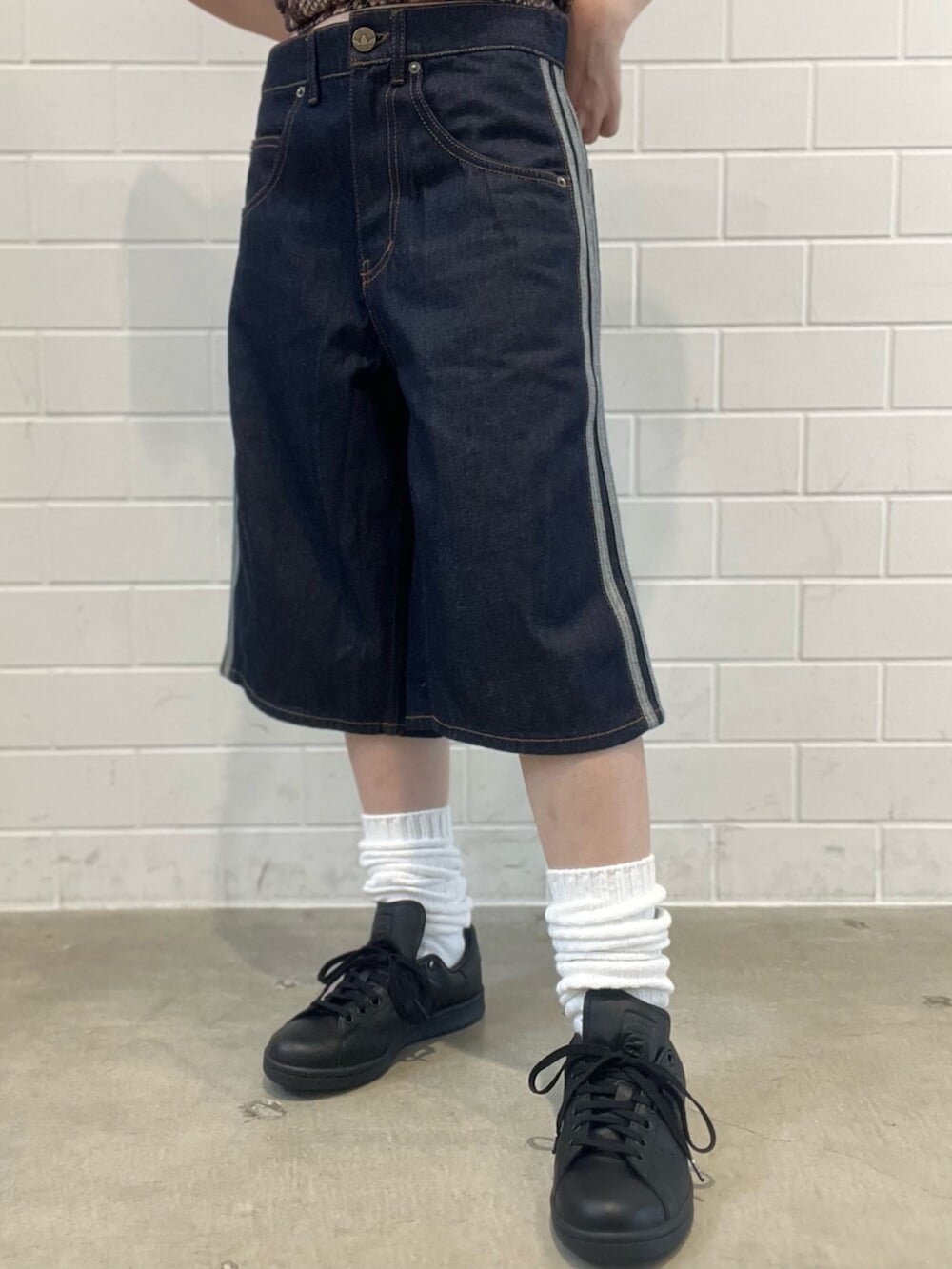 ブラック系のショルダーバッグ、ブルー系のデニムパンツ、ブラック系のスニーカーを着用したレディースの夏コーディネートの5枚目の写真