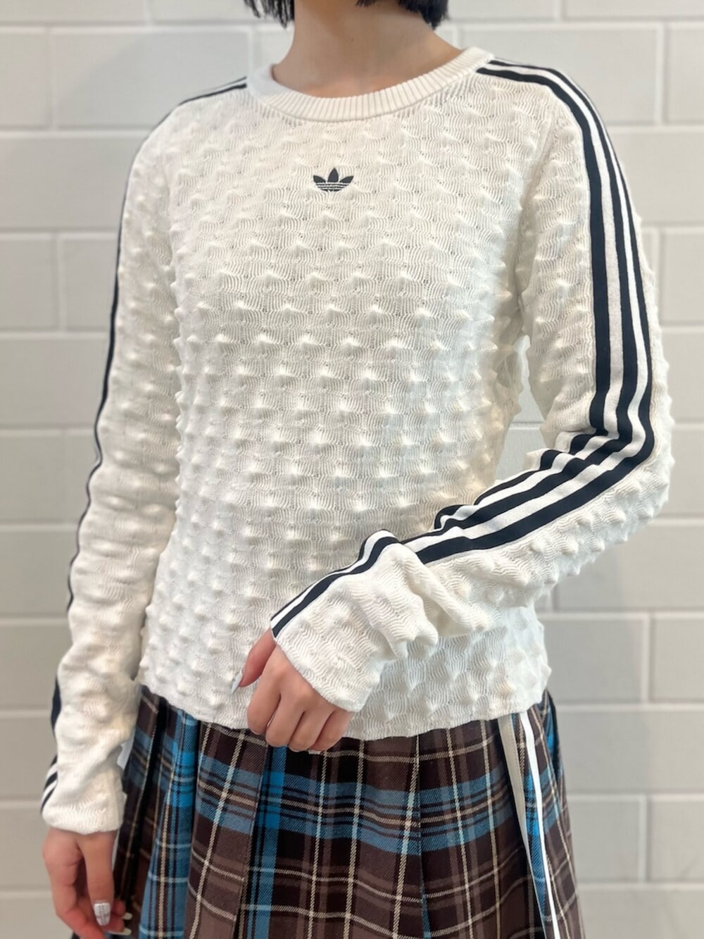 ホワイト系のスウェット、ブラック系のショルダーバッグ、ブラック系のスニーカーを着用したレディースの冬コーディネートの3枚目の写真