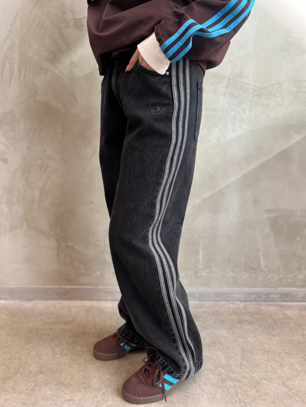 ブラック系のデニムパンツ、ブラウン系のスニーカー、ブラウン系のトップスを着用したレディースの冬コーディネートの5枚目の写真