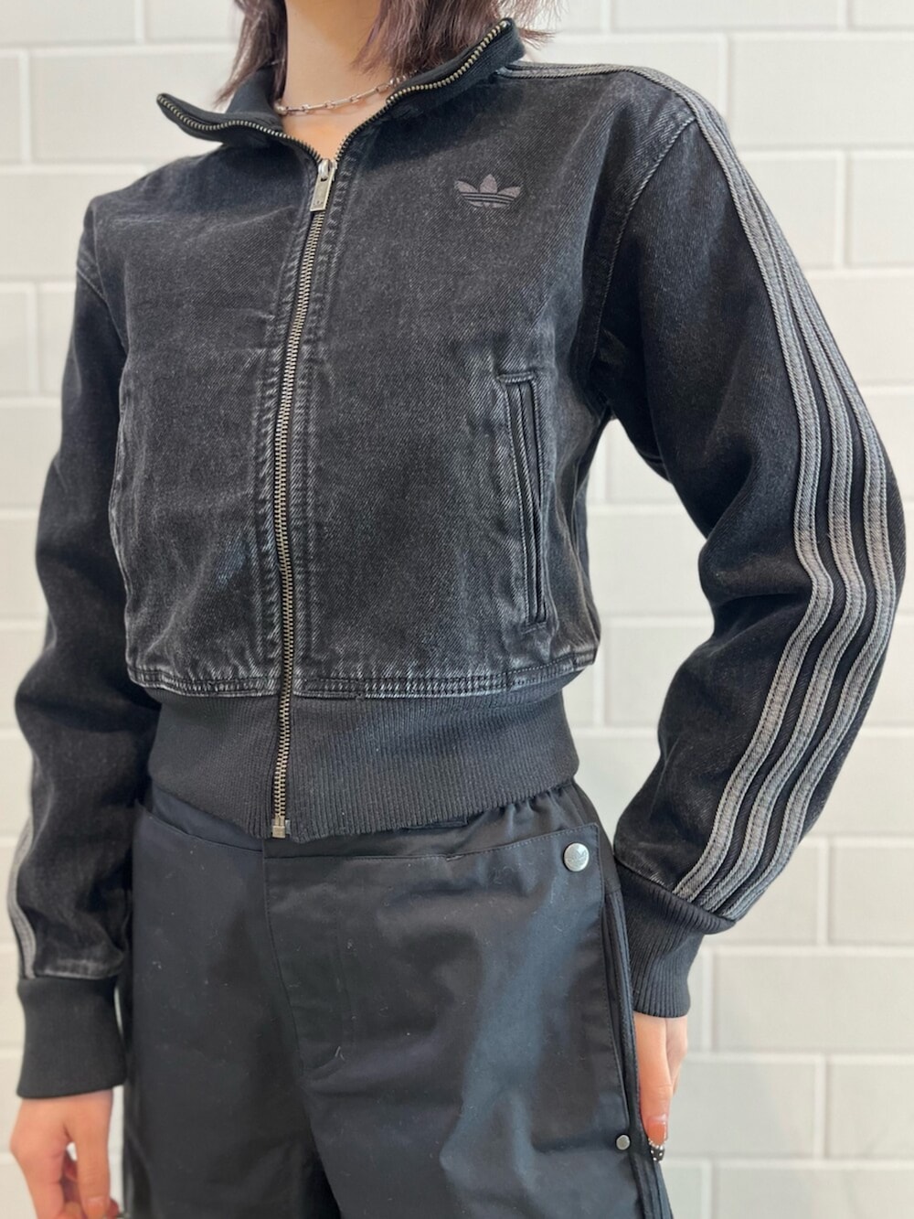 シルバー系のショルダーバッグ、ブラック系のデニムジャケット、ブラック系のその他パンツを着用したレディースの冬コーディネートの3枚目の写真