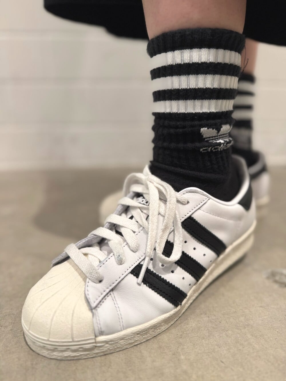 ブラック系のその他パンツ、ホワイト系のシューズ、ブラック系のポロシャツを着用したレディースの秋コーディネートの6枚目の写真