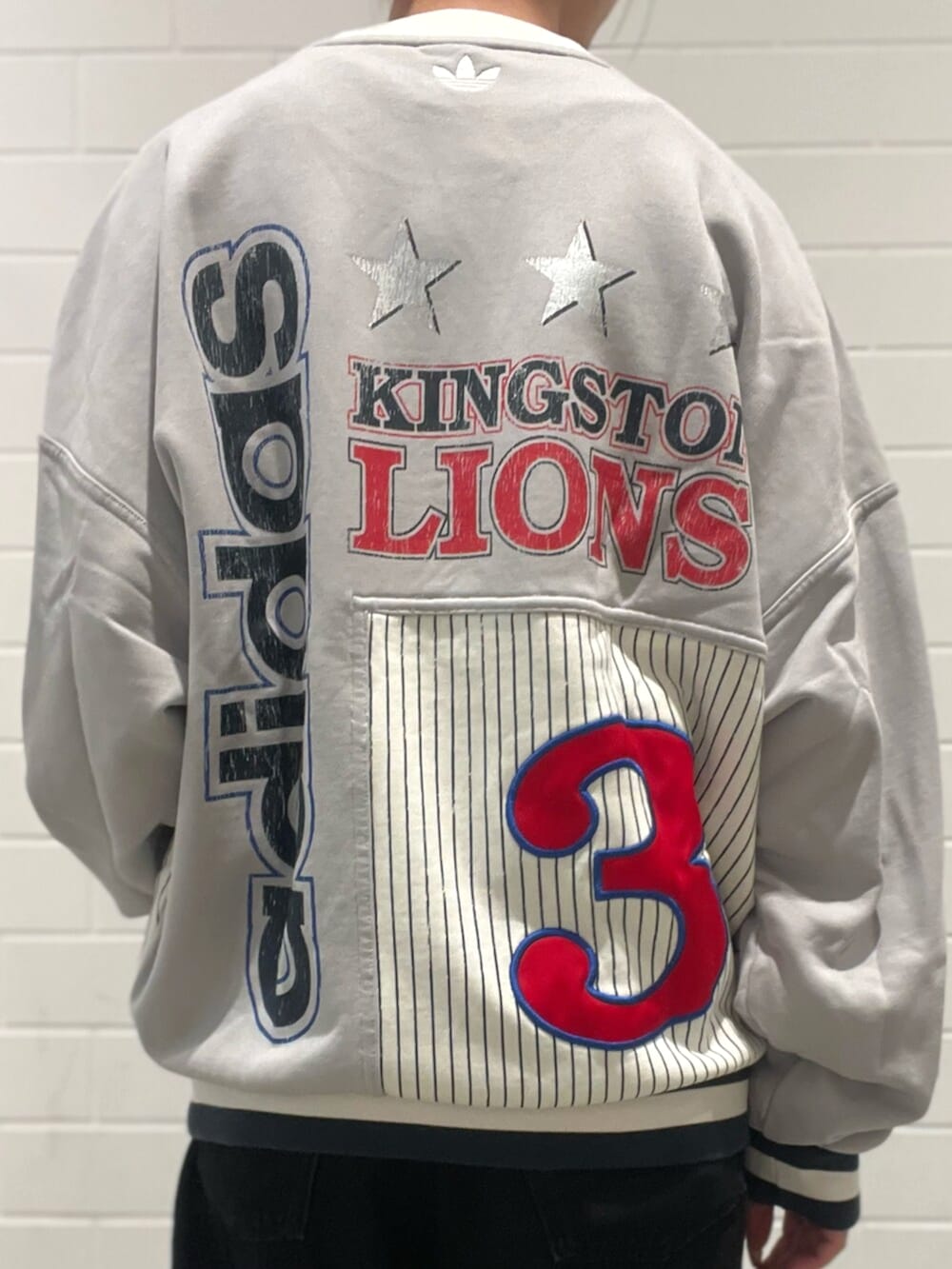 ブラック系のショルダーバッグ、レッド系のスニーカー、ブラック系のデニムパンツを着用したレディースの秋コーディネートの5枚目の写真