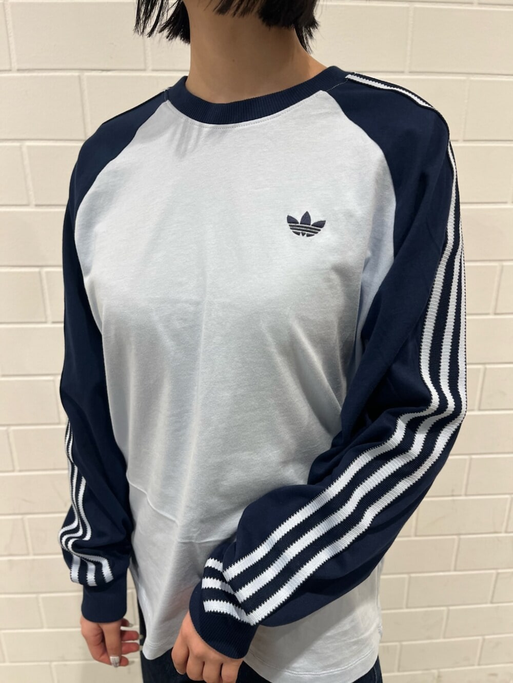 ブラック系のスニーカー、ブルー系のTシャツ/カットソー、ブラック系のトートバッグを着用したレディースの冬コーディネートの4枚目の写真