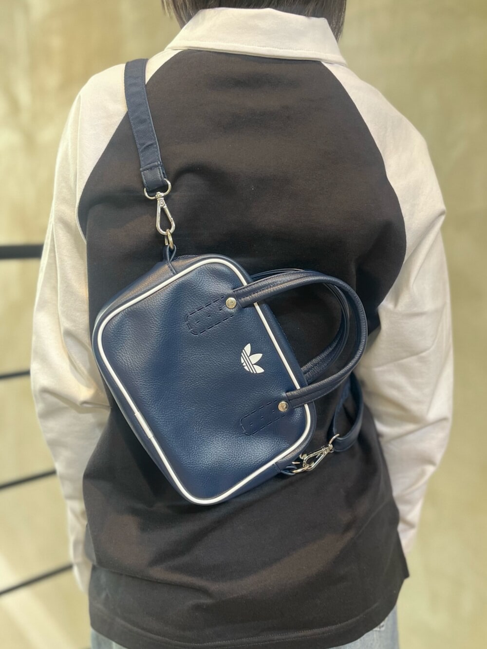 ブルー系のシューズ、ブルー系のショルダーバッグ、ブラック系のポロシャツを着用したレディースの冬コーディネートの5枚目の写真