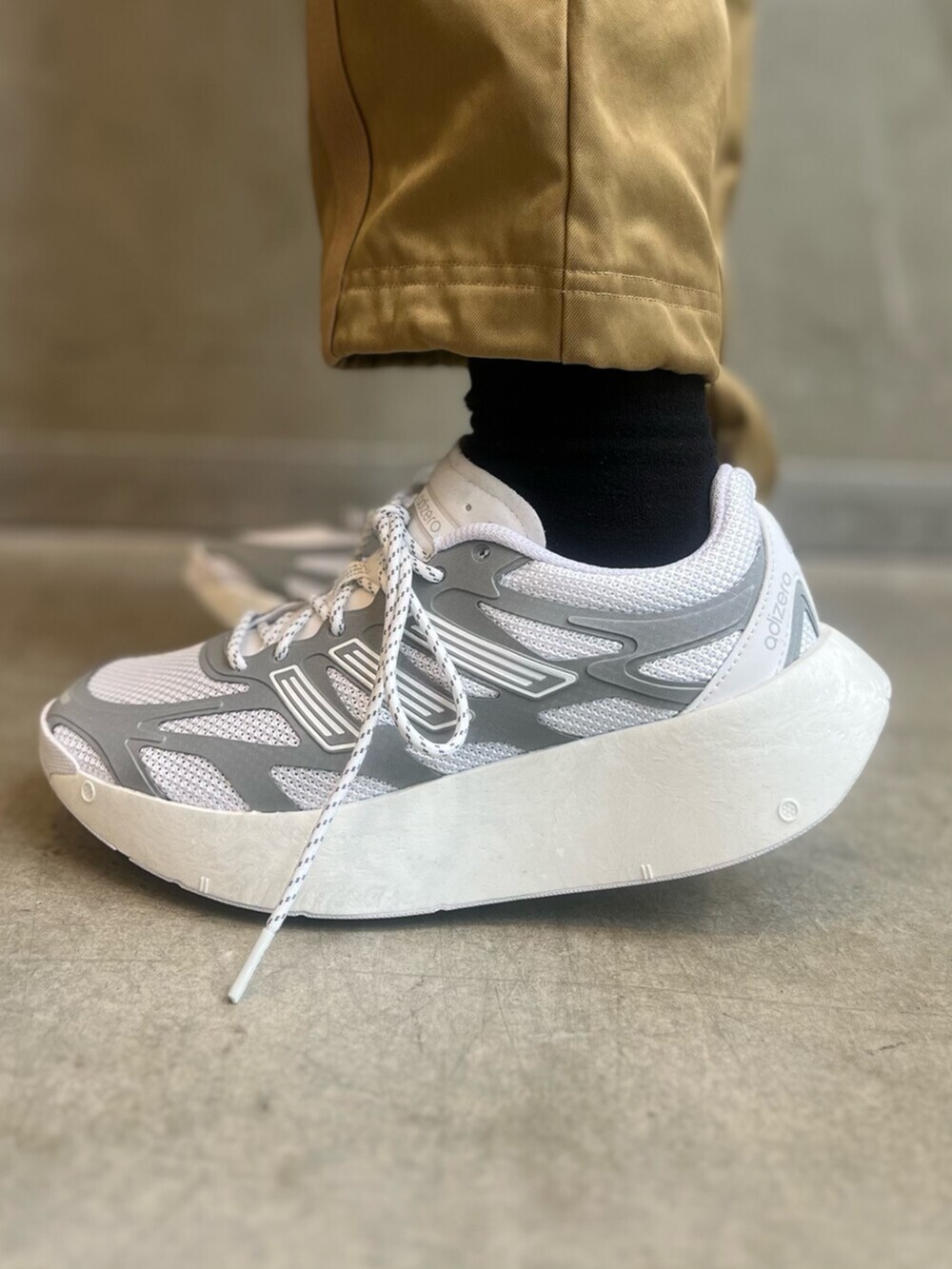 ブラウン系のカーゴパンツ、ホワイト系のシューズ、オレンジ系のパーカーを着用したレディースの冬コーディネートの7枚目の写真